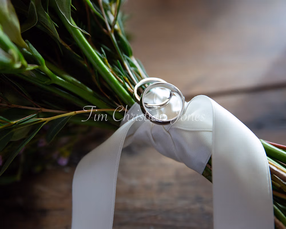 Wedding rings on bridal bouquet flower stems, by a professional Leeds based wedding photographer.