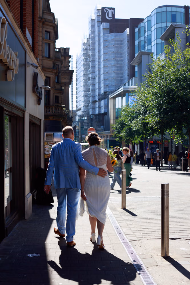 The couple walking toward the Lost & Found Club in Leeds, the groom’s hand resting gently on the bride’s back.