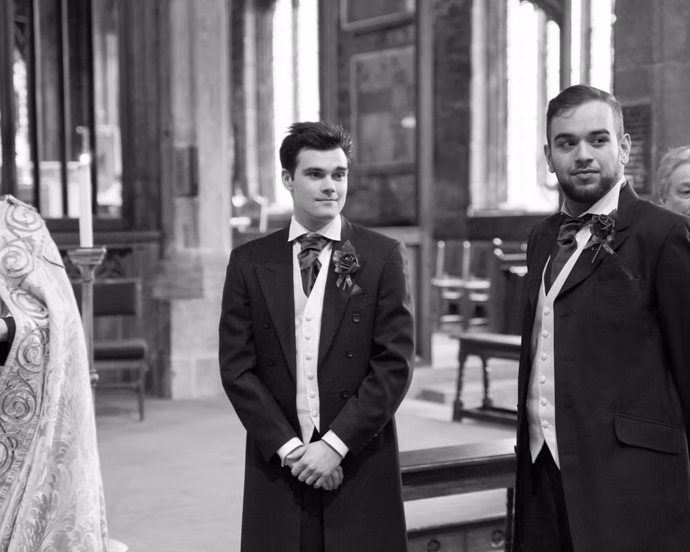 Groom and best man stand and look back as the entrance music plays