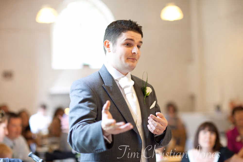 Best man mid-speech, laughing as he shares a story
