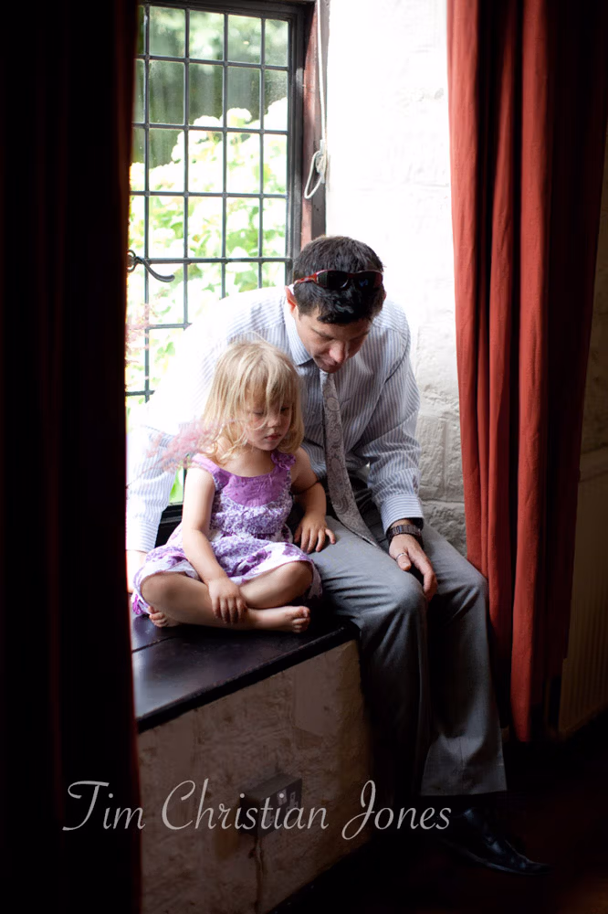 daughter and her father sitting quietly together on a window ledge