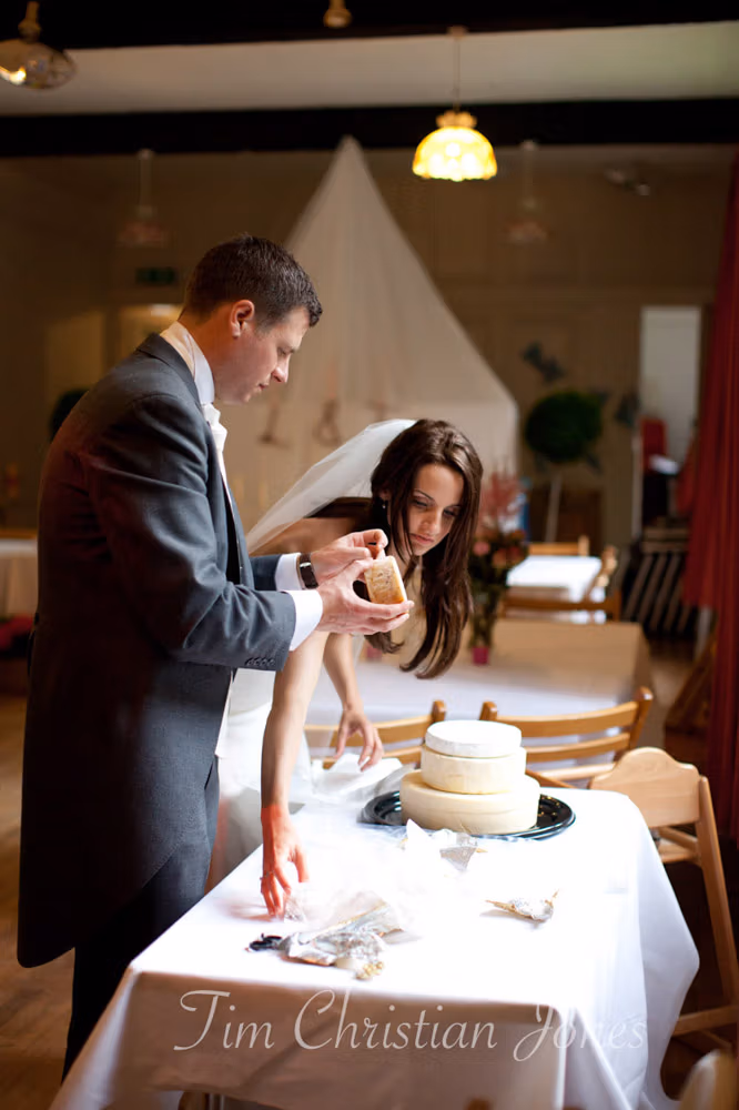 Lowri and Tim assembling their tiered cheese cake together